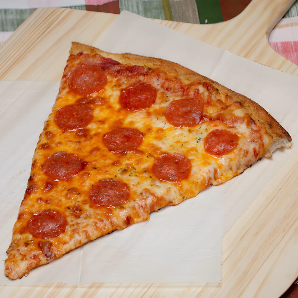 A large slice of Super Fratelli's pepperoni pizza with melted cheese on a wooden peel.